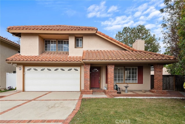 mediterranean / spanish house featuring fence, concrete driveway, a front yard, an attached garage, and a tiled roof