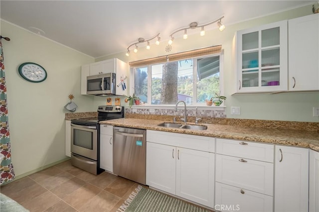 kitchen featuring a sink, white cabinetry, appliances with stainless steel finishes, rail lighting, and glass insert cabinets