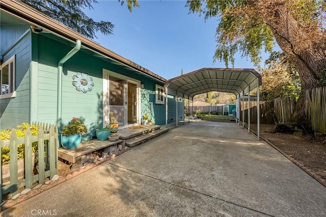 exterior space featuring a detached carport, fence, and driveway