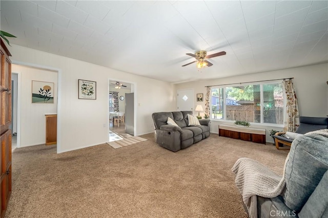 living area with a ceiling fan and carpet flooring