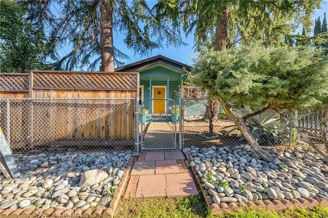 shotgun-style home featuring fence and a gate