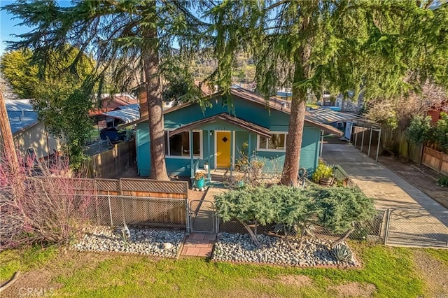 view of front facade featuring a fenced front yard, a carport, and a gate