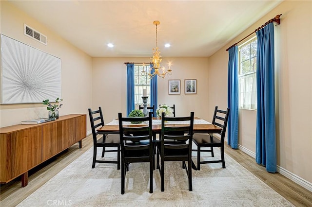 dining room with a chandelier, visible vents, light wood-style flooring, and a healthy amount of sunlight