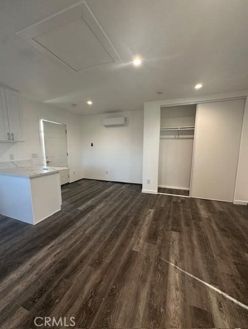 interior space with dark wood finished floors, recessed lighting, and a wall unit AC