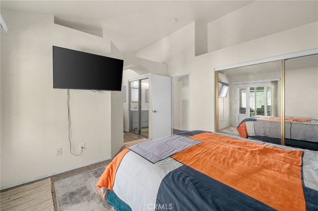 bedroom with a closet, connected bathroom, and vaulted ceiling