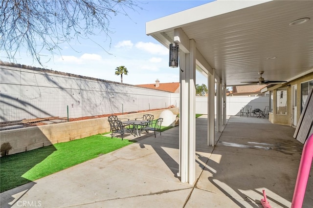 view of patio with outdoor dining space, a fenced backyard, and ceiling fan