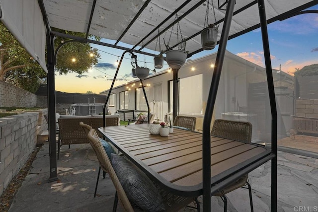 patio terrace at dusk with outdoor dining space and fence