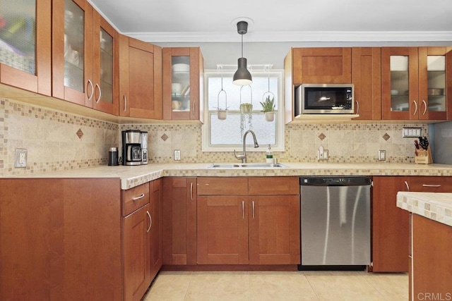 kitchen with a sink, brown cabinets, appliances with stainless steel finishes, and light countertops