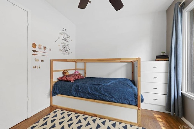 bedroom featuring vaulted ceiling, wood finished floors, baseboards, and ceiling fan