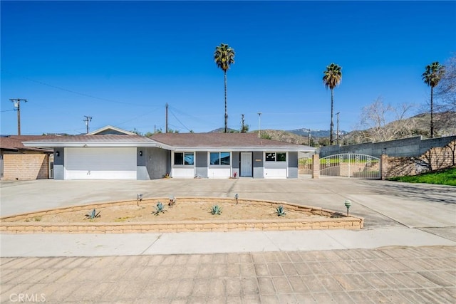 ranch-style home with a gate, fence, a garage, and driveway