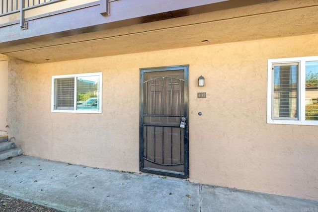 entrance to property featuring stucco siding