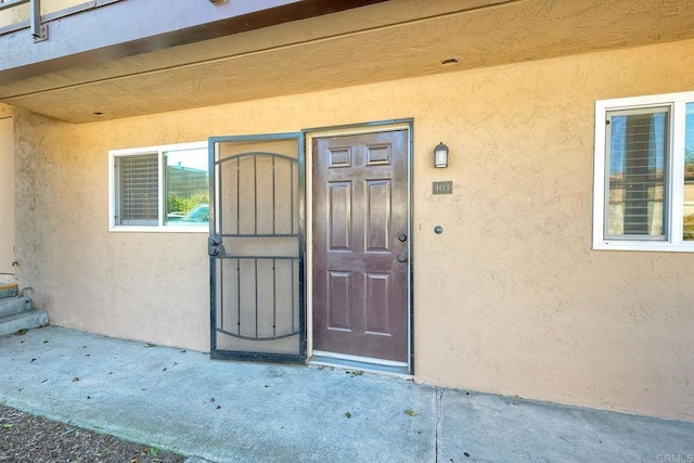 view of exterior entry featuring stucco siding