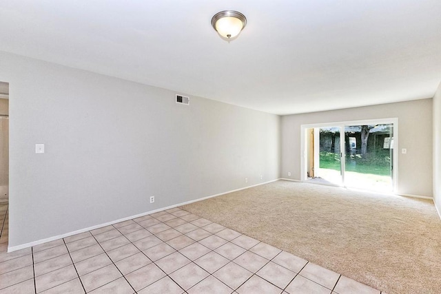 spare room featuring visible vents, baseboards, and light colored carpet