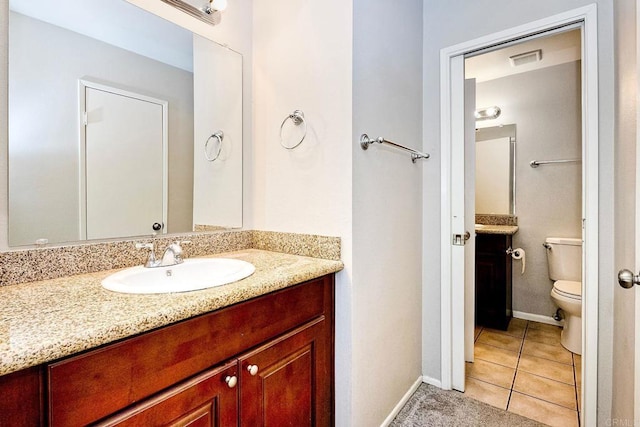 bathroom with tile patterned floors, visible vents, toilet, baseboards, and vanity