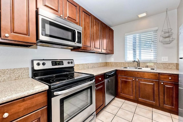 kitchen featuring light tile patterned floors, appliances with stainless steel finishes, light countertops, and a sink