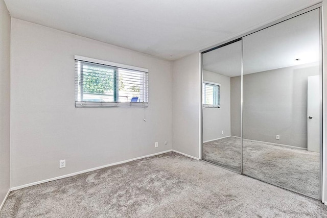 unfurnished bedroom featuring a closet, baseboards, and carpet flooring