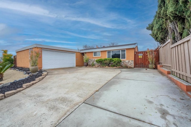 single story home with stucco siding, a garage, and fence