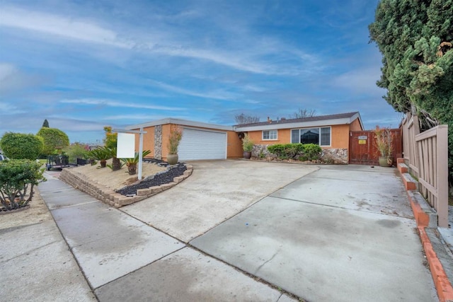 single story home with stucco siding, concrete driveway, and fence