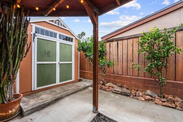 view of patio with an outdoor structure and fence