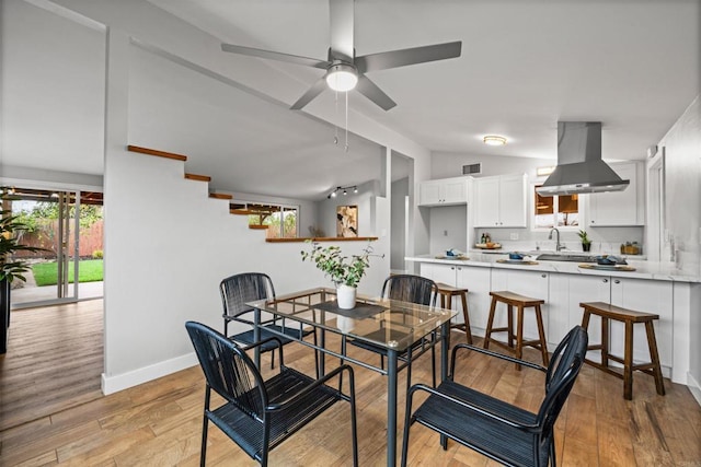 dining room with visible vents, light wood-style flooring, baseboards, and lofted ceiling