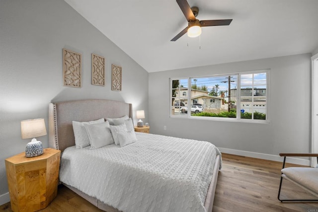 bedroom featuring ceiling fan, baseboards, wood finished floors, and vaulted ceiling