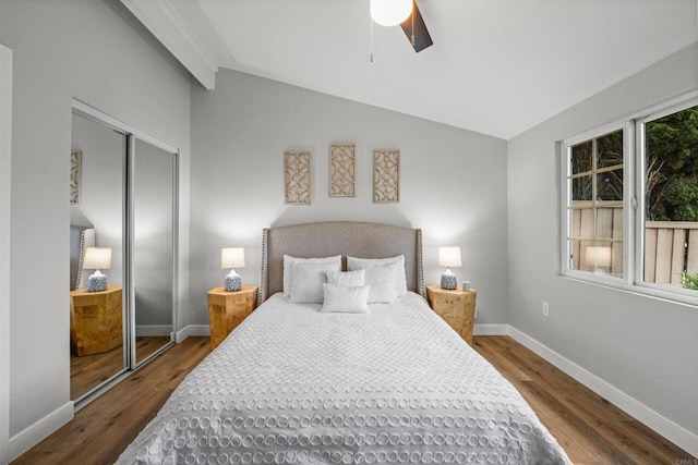 bedroom featuring ceiling fan, baseboards, vaulted ceiling, wood finished floors, and a closet