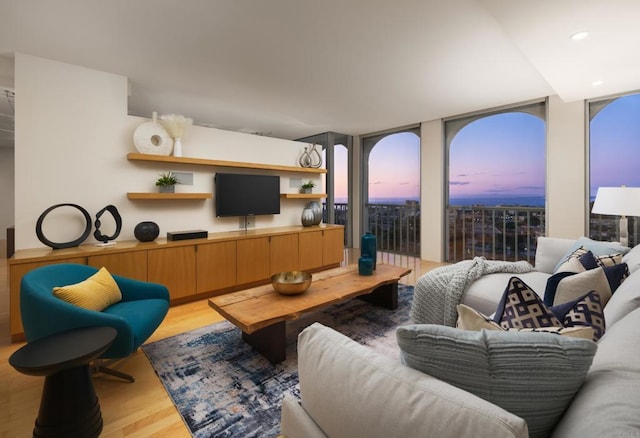 living room featuring recessed lighting, a wall of windows, and light wood-type flooring