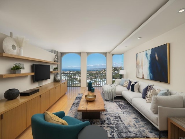 living area with recessed lighting, light wood-style floors, and expansive windows