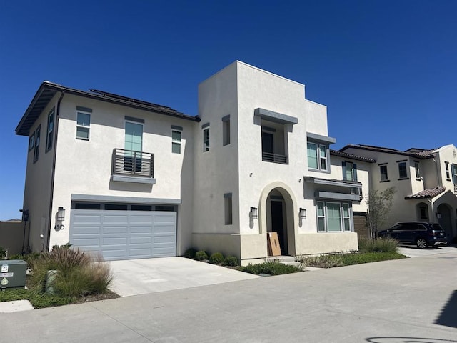 view of front of property with stucco siding, an attached garage, and concrete driveway