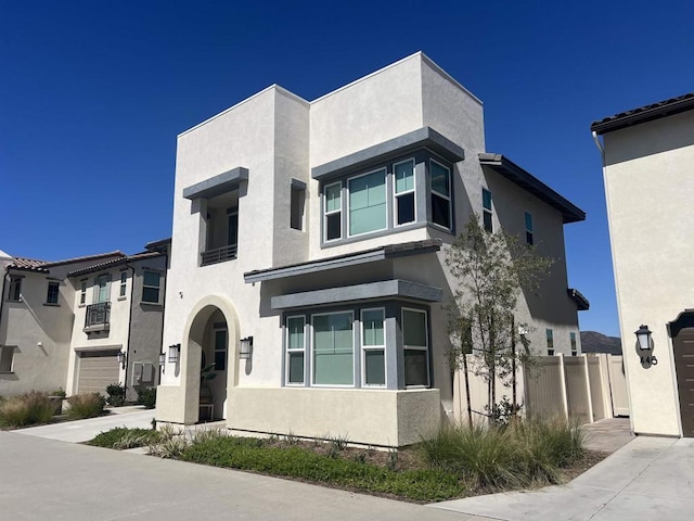 view of front of house featuring stucco siding and fence