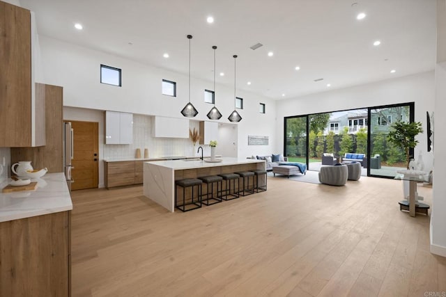 kitchen with light wood-style flooring, modern cabinets, light countertops, and a sink