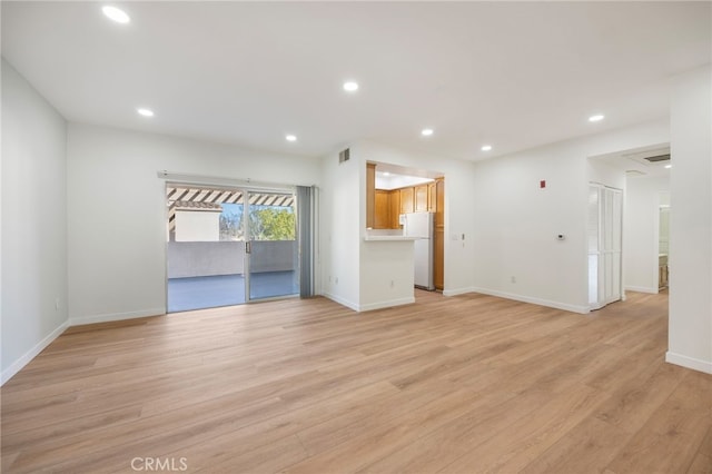 unfurnished living room featuring light wood-type flooring, visible vents, baseboards, and recessed lighting