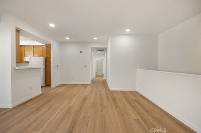 unfurnished living room featuring recessed lighting, light wood-type flooring, and baseboards