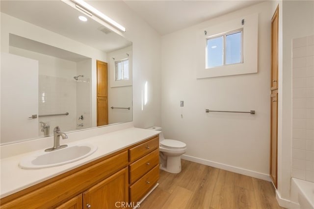 bathroom featuring vanity, toilet, wood finished floors, and baseboards