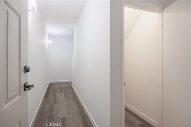 corridor featuring dark wood-style floors and baseboards