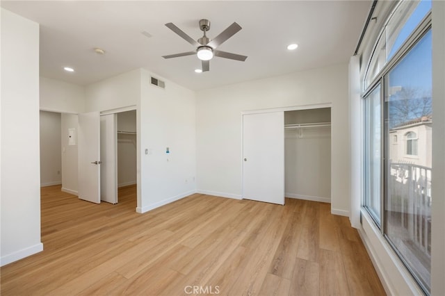 unfurnished bedroom with visible vents, multiple windows, baseboards, and light wood finished floors