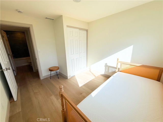 bedroom featuring baseboards, visible vents, a closet, and light wood-type flooring