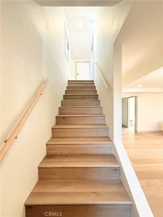 stairs featuring recessed lighting and wood finished floors