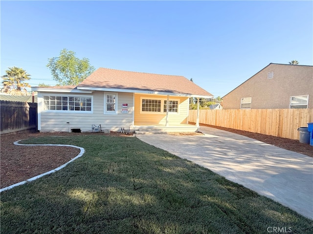 back of house with a lawn, driveway, and a fenced backyard