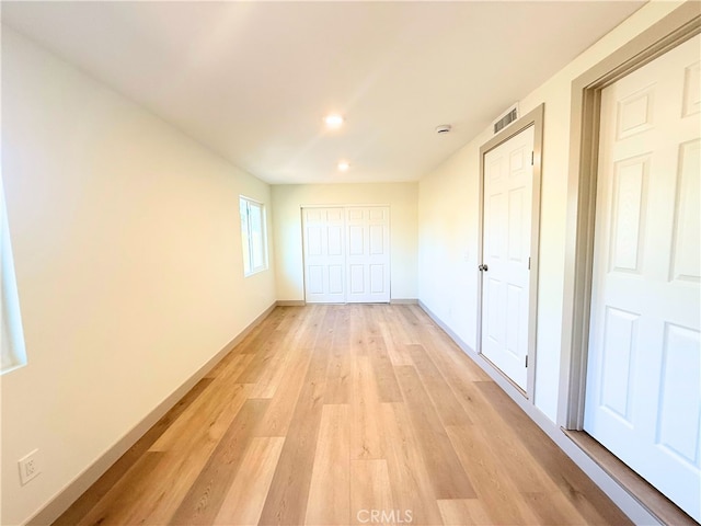 unfurnished bedroom with baseboards, visible vents, recessed lighting, a closet, and light wood-type flooring