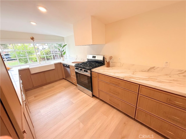 kitchen with light countertops, light wood-type flooring, recessed lighting, appliances with stainless steel finishes, and a sink