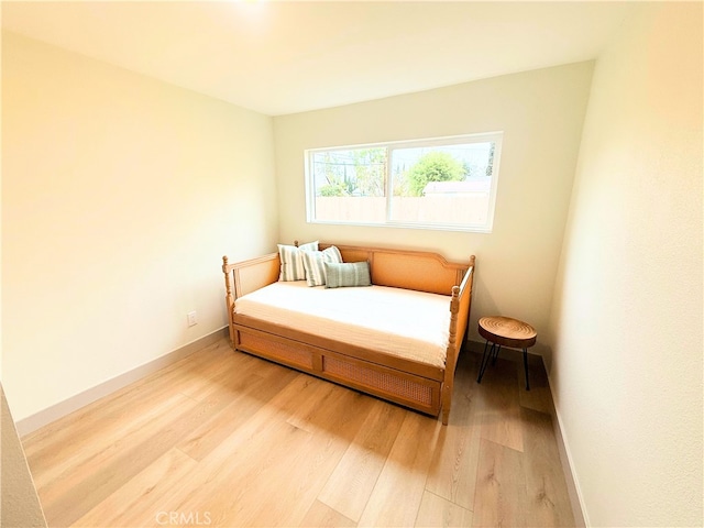 bedroom featuring baseboards and light wood finished floors