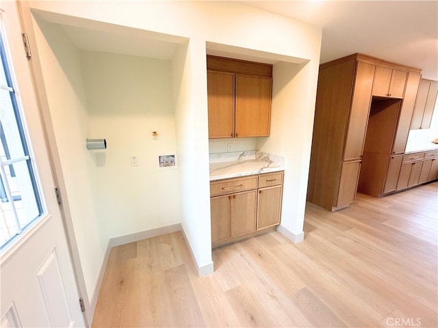 kitchen with light countertops, baseboards, and light wood-style floors