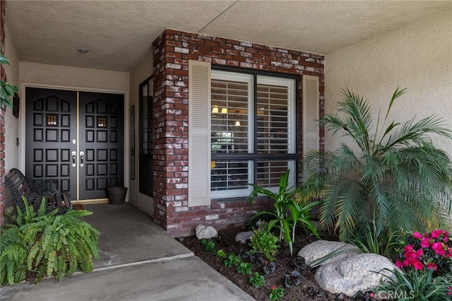 property entrance with brick siding and stucco siding