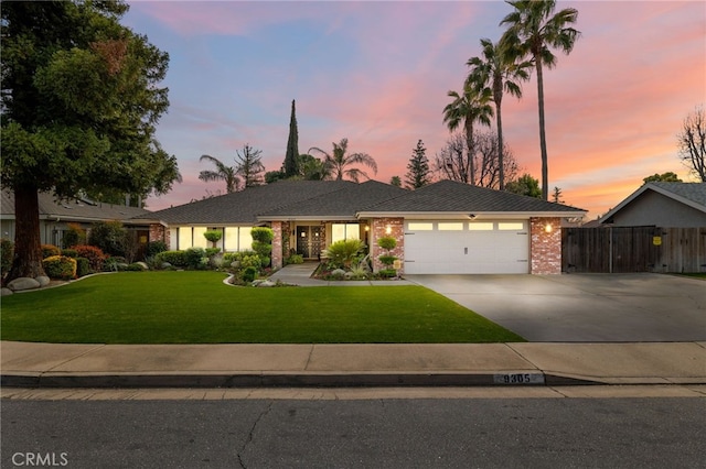 ranch-style home with driveway, an attached garage, a front yard, and fence