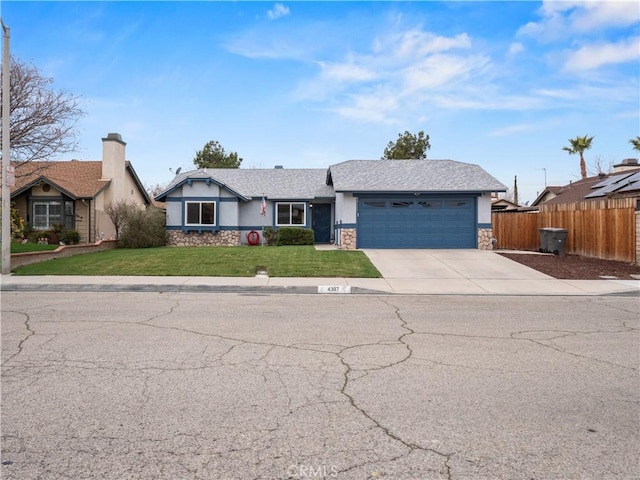 ranch-style home with a front yard, fence, an attached garage, stucco siding, and stone siding