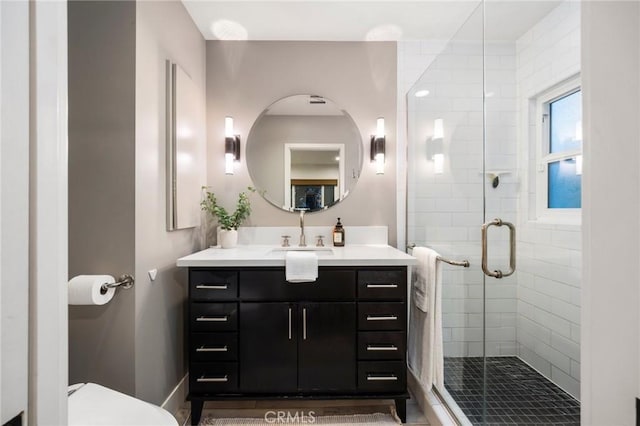 bathroom featuring vanity, toilet, and a stall shower