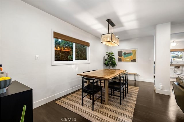 dining space with baseboards and wood finished floors