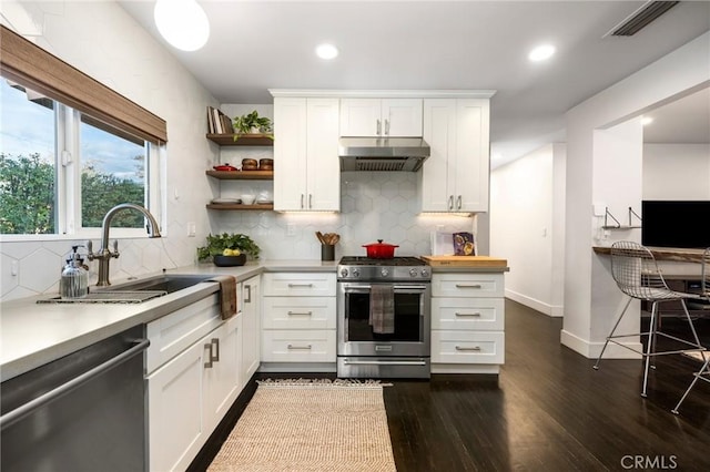 kitchen with under cabinet range hood, open shelves, a sink, stainless steel appliances, and light countertops