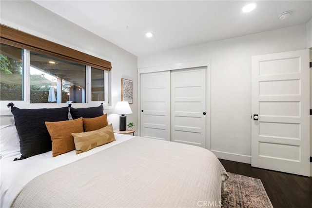 bedroom with recessed lighting, a closet, baseboards, and dark wood finished floors